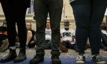 DeSantis signs bills targeting LGBTQ+: people sitting on the ground looking through legs of people standing