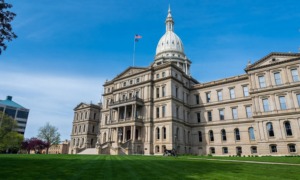 Some Michigan districts are not equitably funding schools with higher needs: view of Michigan capitol building from the front lawn with blue sky
