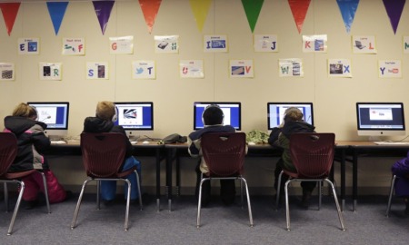 Veto stands_Transgender pronouns OK in North Dakota schools: students at computers in a classroom with decorated wall